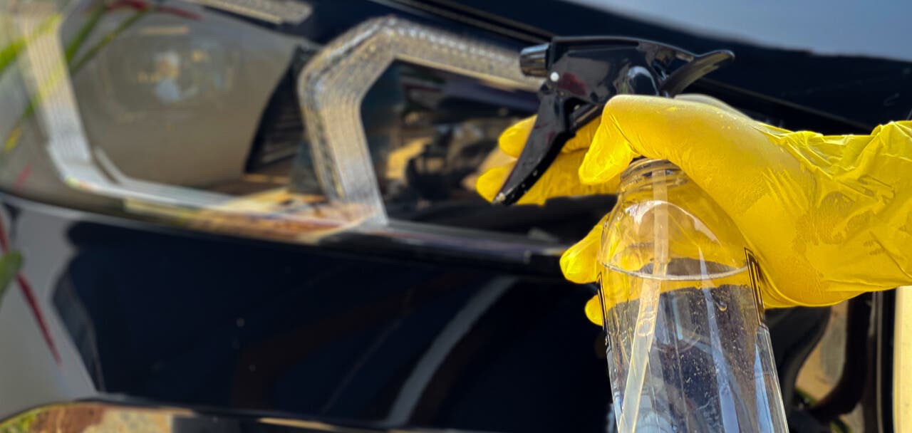 Spraying vinegar solution on car headlights