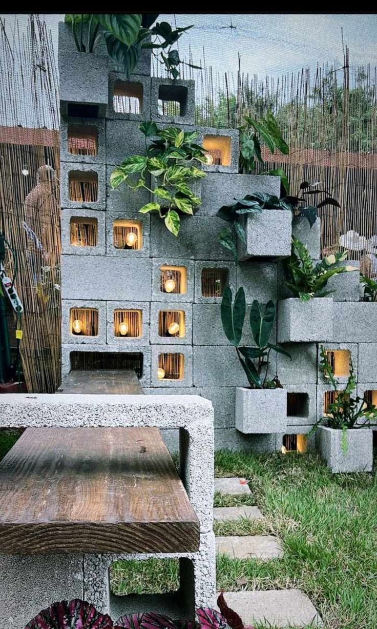 Concrete block garden wall with plants and warm lighting