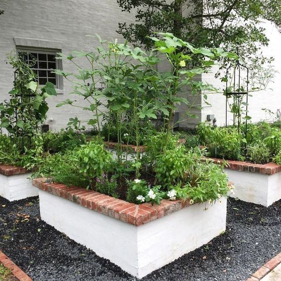 White painted concrete block garden beds with brick trim