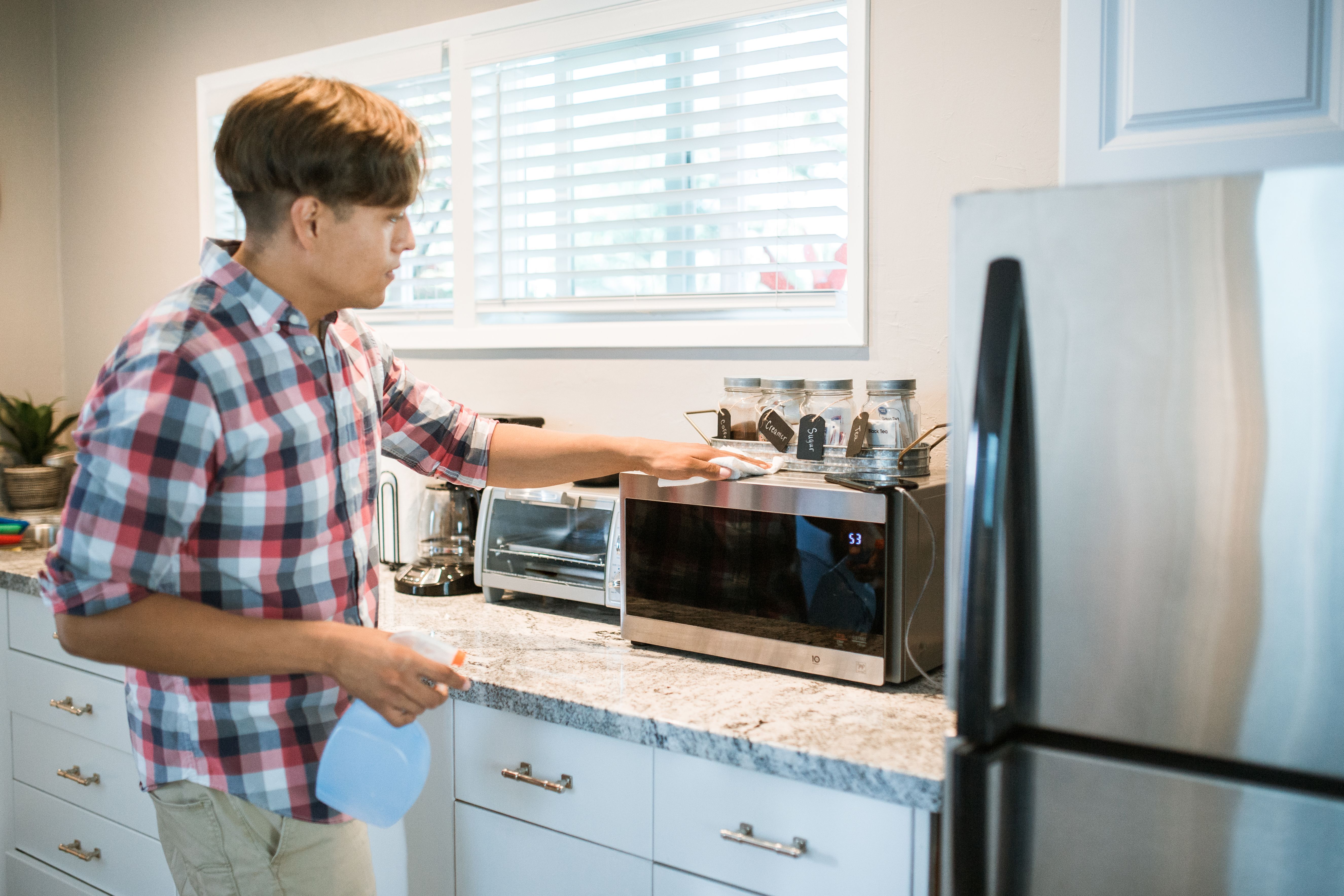 A man cleaning a microwave oven