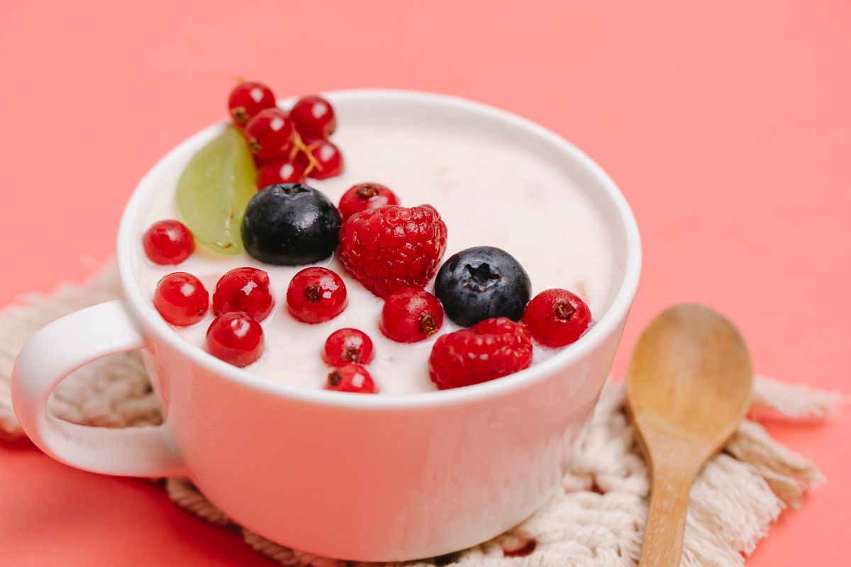 A bowl of plain yogurt topped with berries and nuts
