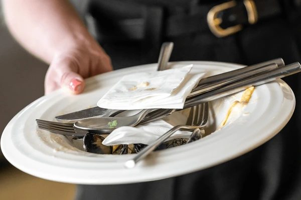 Hand holding a dirty plate