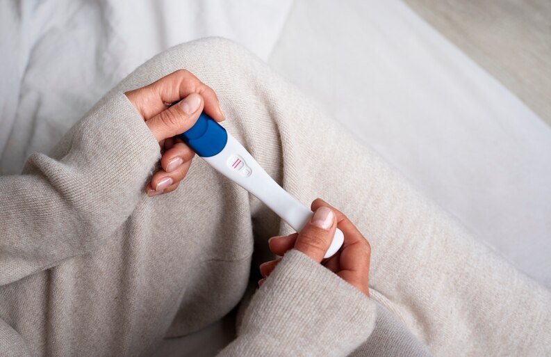 Woman holding positive pregnancy tests