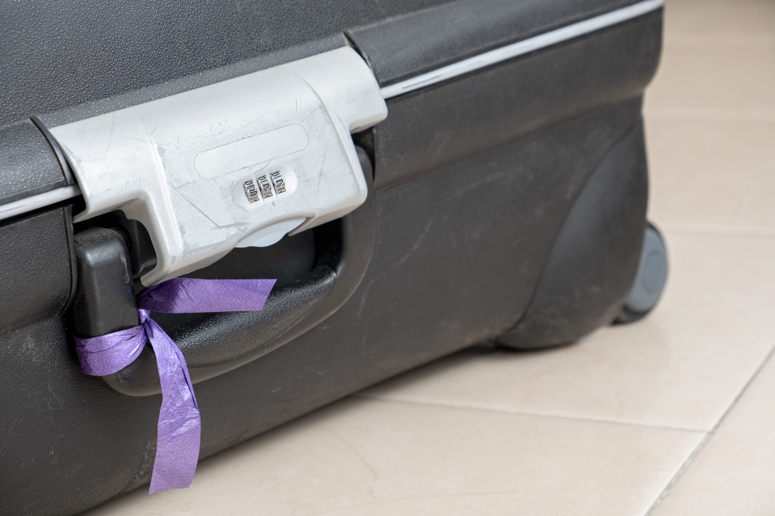 Suitcase with attached ribbon