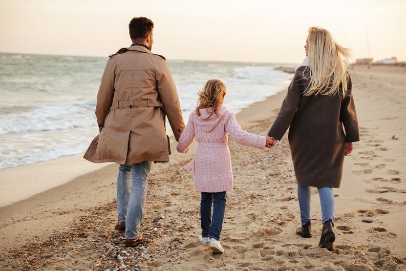 Family with a little girl on the beach